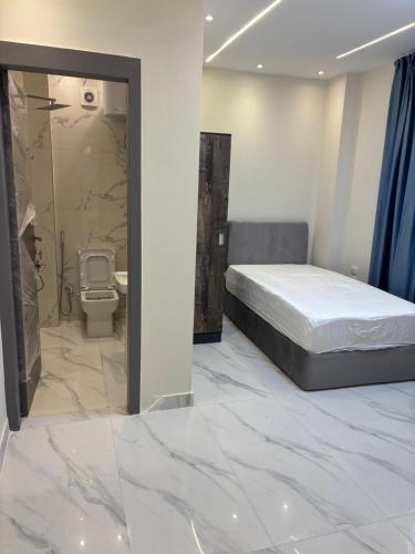 a bedroom with a bed and a shower and a toilet at Zayed hotel in Sheikh Zayed