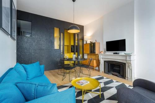 un salon avec un canapé bleu et une table dans l'établissement Hallmark - Furnished apartment - Downtown Lyon, à Lyon