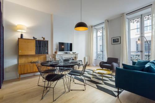 un salon avec une table, des chaises et un canapé dans l'établissement Hallmark - Furnished apartment - Downtown Lyon, à Lyon