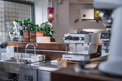 a kitchen with a sewing machine on a counter at Chengdu Local Tea Hostel - Short Walk To Taikooli - Chill & Social Coffee Lounge - Metro downstairs - Free Activities - Friendly English Speaking Staff - Tibet, Panda, Buddha & Snow Mountain Tours in Chengdu