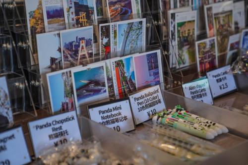 a display of books on a table with a cake at Chengdu Local Tea Hostel - Short Walk To Taikooli - Chill & Social Coffee Lounge - Metro downstairs - Free Activities - Friendly English Speaking Staff - Tibet, Panda, Buddha & Snow Mountain Tours in Chengdu
