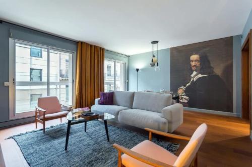 un salon avec un canapé et une peinture d'un homme dans l'établissement Stella - Furnished apartment - Downtown Lyon, à Lyon