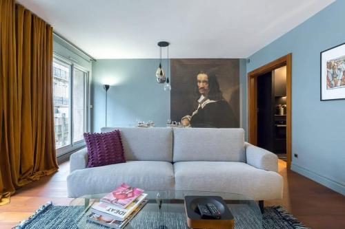 un salon avec un canapé et une peinture d'un homme dans l'établissement Stella - Furnished apartment - Downtown Lyon, à Lyon