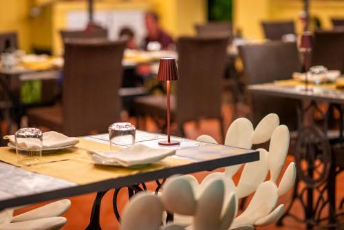a table and chairs with plates and a lamp on it at Hotel Villa Rita in Paestum