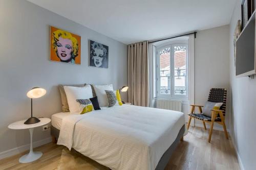une chambre avec un grand lit blanc et une chaise dans l'établissement Gasparin - Furnished apartment - Downtown Lyon, à Lyon