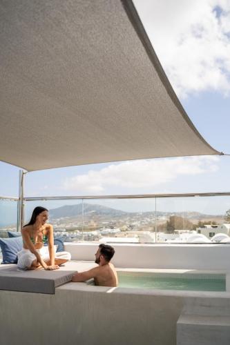 a man and woman sitting in a bath tub on a yacht at Aressana Spa Hotel & Suites - Small Luxury Hotels of the World in Fira