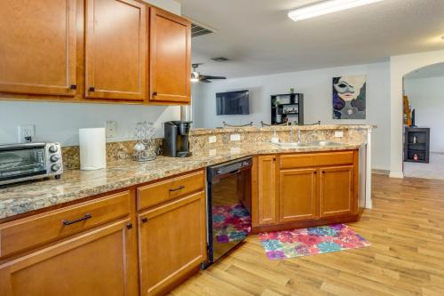 a kitchen with wooden cabinets and a counter top at Tavares Retreat with Covered Patio and Private Yard in Tavares