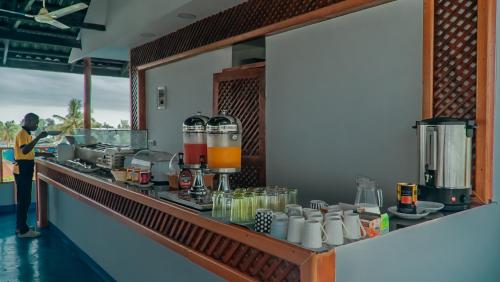 a kitchen with a counter with a person standing in front at Golden Hotel in Nungwi