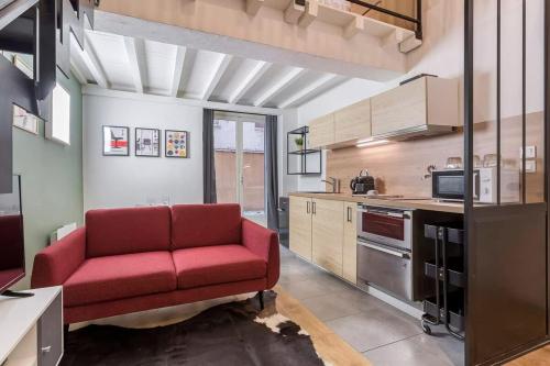 un salon avec un canapé rouge dans une cuisine dans l'établissement Chardonnet - Furnished apartment - Downtown Lyon, à Lyon