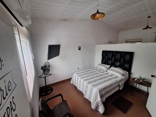 a bedroom with a bed with a striped comforter at OUR HOME SAN ANTONIO in Cali