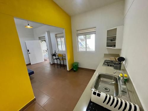 a kitchen with a sink and a yellow wall at OUR HOME SAN ANTONIO in Cali