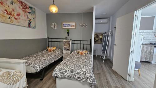a bedroom with two beds and a hallway at Lolita's house torre del oro in Seville