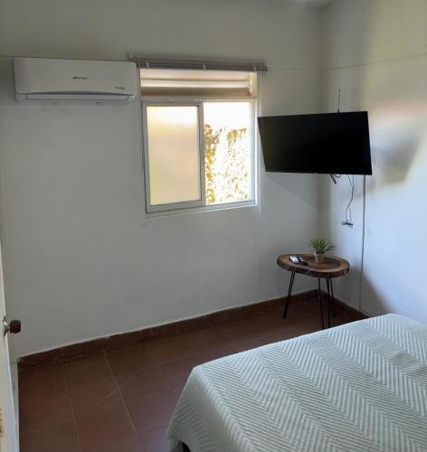 a bedroom with a bed and a window and a television at OUR HOME SAN ANTONIO in Cali