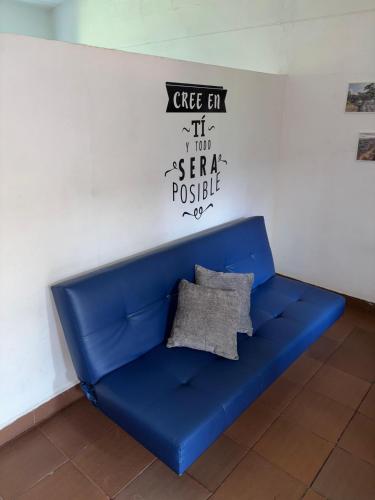 a blue couch in a room with a sign on a wall at OUR HOME SAN ANTONIO in Cali