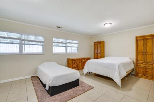 two beds in a bedroom with white walls and windows at Home 3 Mi to Homosassa Springs Wildlife State Park in Homosassa