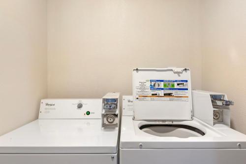 a small white room with a washing machine in a room at Quality Inn Columbia Mall in Grand Forks