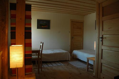 a bedroom with two beds and a table with a lamp at Przystanek Rospuda in Sucha Wieś