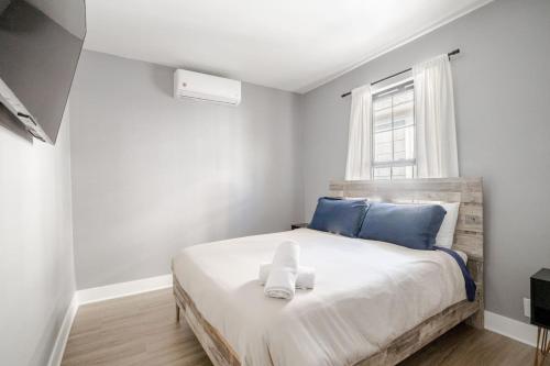 a bedroom with a bed with blue pillows and a window at 3 Bedrm Apt at Black Rock Suites in Bridgeport