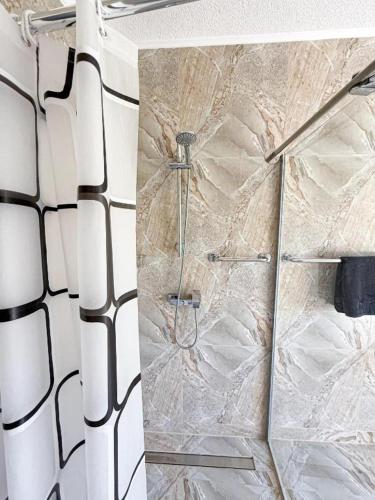 a bathroom with a shower with a marble wall at Apartments Rose in Rakovica