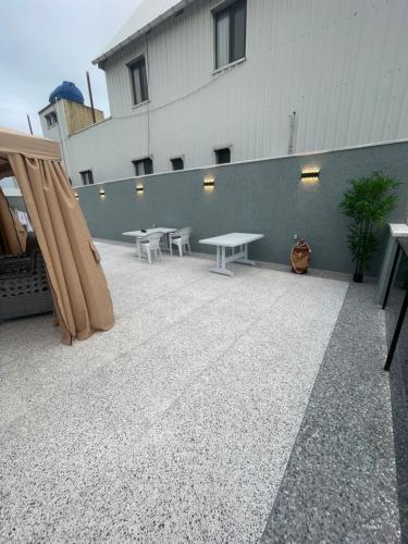 a patio with tables and benches in front of a building at Nika house in Ureki