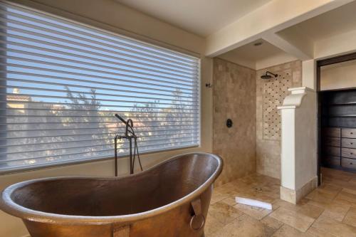 a bath tub in a bathroom with a window at Ocean & Desert Hacienda Charm Villa in San José del Cabo