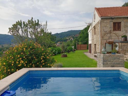 a swimming pool in front of a house at O Refuxio de Tebra in Tebra