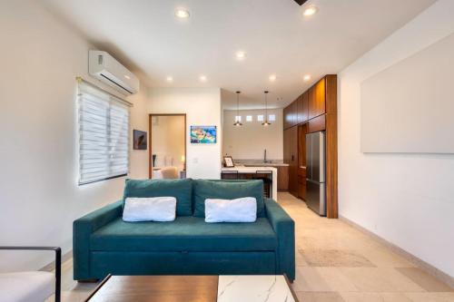 a living room with a blue couch and a kitchen at Meditation Haven 1BR Pitahaya in San José del Cabo
