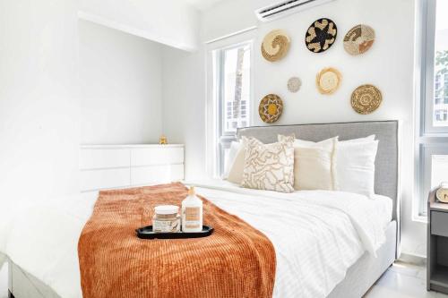 a white bedroom with a bed with a tray on it at 6 Bed 4 Bath Family Houses A8 w 2 Private Pools Dorado del Mar in Dorado