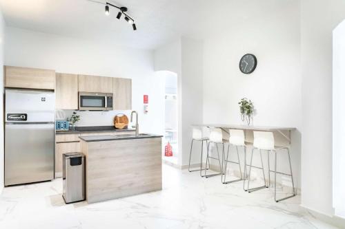 a white kitchen with stainless steel appliances and bar stools at 6 Bed 4 Bath Family Houses A8 w 2 Private Pools Dorado del Mar in Dorado