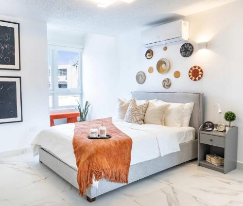 a white bedroom with a bed with a orange blanket on it at 6 Bed 4 Bath Family Houses A8 w 2 Private Pools Dorado del Mar in Dorado