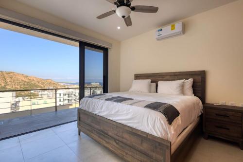 a bedroom with a bed and a large window at New 3 BD Condo with Pool and Gym in Cabo San Lucas