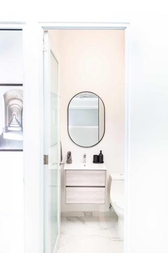 a white bathroom with a mirror and a sink at 6 Bed 4 Bath Family Houses A8 w 2 Private Pools Dorado del Mar in Dorado