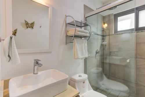 クルス・デ・ウアナカストレにあるAmazing 2BD condo with Roof shared poolの洗面台とガラスのシャワーを備えたバスルーム