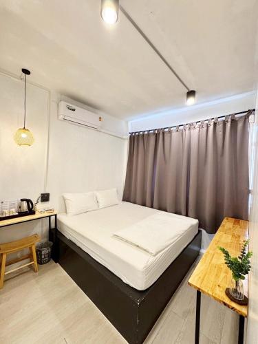 een kleine kamer met een bed en een tafel bij EK Silomhostel in Bangkok