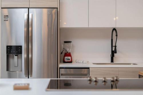a kitchen with a stainless steel refrigerator and a sink at Find peace in this 2 BD condo in Cabo San Lucas