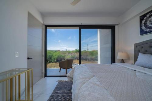 a bedroom with a bed and a large glass window at Find peace in this 2 BD condo in Cabo San Lucas