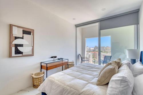 una camera da letto con un letto, una scrivania e una finestra di 3 BD Penthouse Jacuzzi BBQ Near Medano Beach a Cabo San Lucas