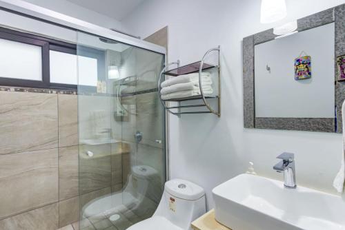 a bathroom with a shower and a toilet and a sink at 2BD Condo with Roof shared Pool in Cruz de Huanacaxtle