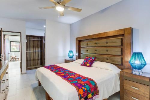 a bedroom with a large bed and a ceiling fan at 2BD Condo with Roof shared Pool in Cruz de Huanacaxtle