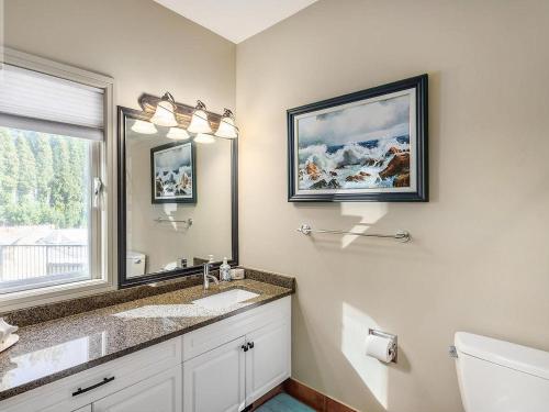 a bathroom with a sink and a mirror at Under the Tree - Bed & Breakfast in Kelowna