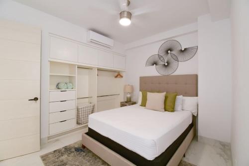 a white bedroom with a bed and white cabinets at AMATERRA modernos aptos cerca a la playa in Cabo San Lucas