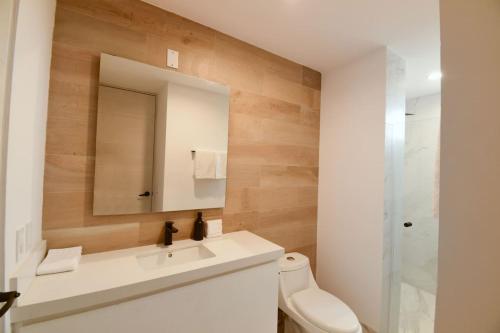 a bathroom with a sink and a mirror and a toilet at AMATERRA modernos aptos cerca a la playa in Cabo San Lucas