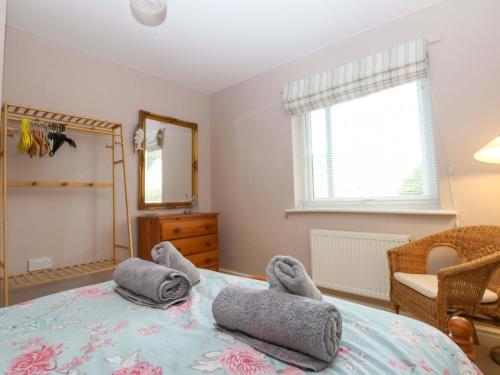 a bedroom with a bed with towels on it at Machlud Ynys in Y Felinheli