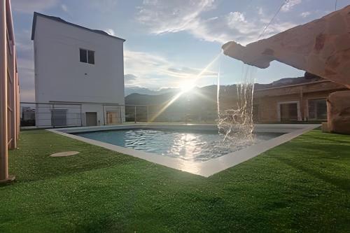 a person is spraying water into a swimming pool at Piscina, jacuzzi en la flora Cali in Cali