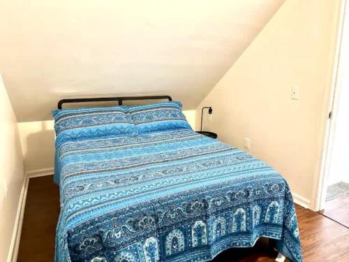 a bed with a blue blanket on top of it at Pontiac Family-Friendly 3BR home in Pontiac