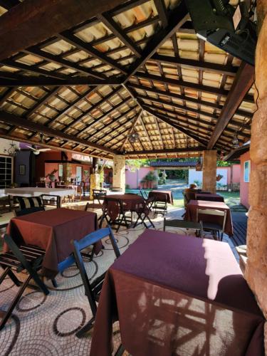 ein Raum mit Tischen und Stühlen und einer Holzdecke in der Unterkunft Hospedagem Majestade in Paraty