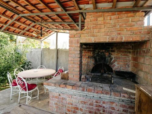 a brick fireplace with a table and chairs on a patio at Daydream Villas in Shkodër