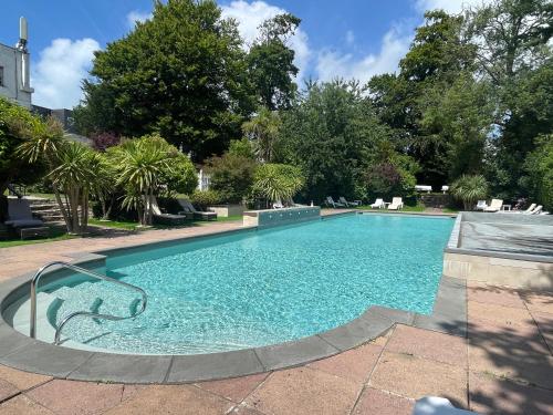a large swimming pool with blue water in a yard at Durrant House Hotel in Bideford