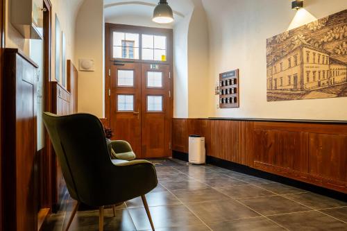 a waiting room with a chair and a door at Rezidencia Levočský Pivovar in Levoča