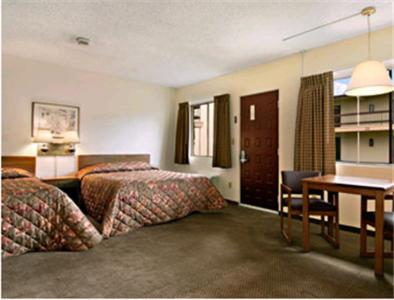 a hotel room with two beds and a desk at Travelers Inn in Longview